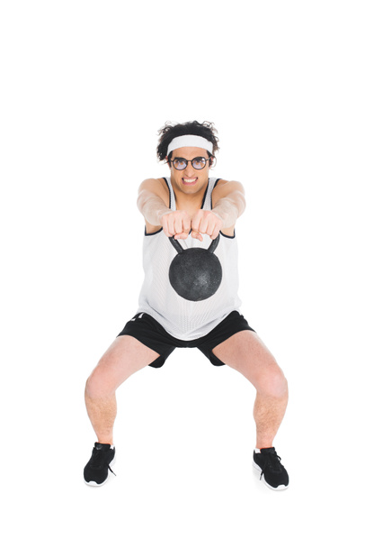 Skinny sportsman in eyeglasses holding kettlebell in hands isolated on white - Фото, изображение