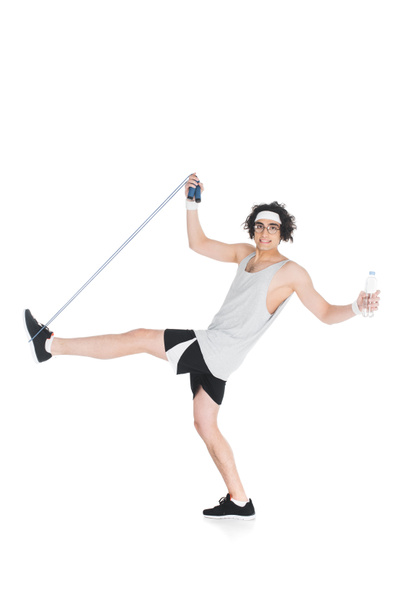 Skinny sportsman in eyeglasses with jump rope and bottle of water isolated on white - Foto, Imagem