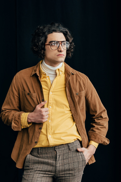Young stylish man in eyeglasses looking away isolated on black - Φωτογραφία, εικόνα