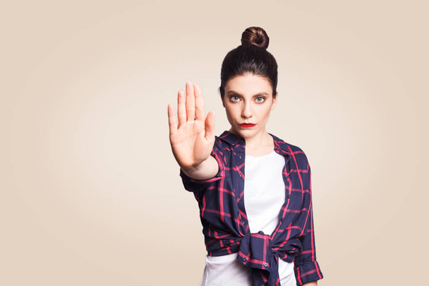 young annoyed woman with bad attitude making stop gesture with her palm outward expressing denial, negative human emotions concept  - Фото, изображение