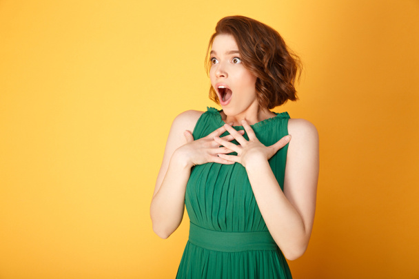 portrait of young shocked woman looking away isolated on orange - Photo, Image