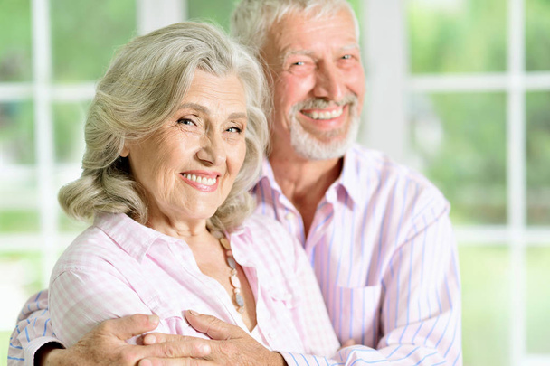 Porträt eines glücklichen Seniorenpaares, das zu Hause posiert - Foto, Bild