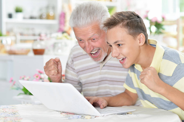 muotokuva poika ja isoisä kannettavan tietokoneen kotona - Valokuva, kuva