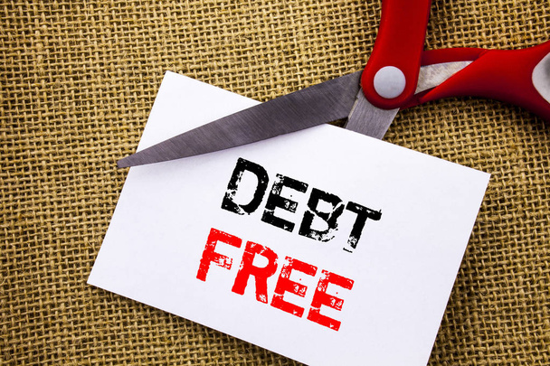 Handwriting text showing Debt Free. Conceptual photo Credit Money Financial Sign Freedom From Loan Mortage written on Sticky Note Paper Cutting by Scissors on the textured background - Photo, Image