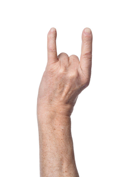 Hand of senior woman showing devil horns sign isolated on white background - Foto, immagini