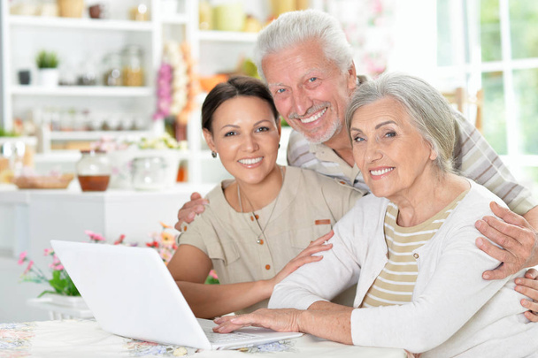 happy senior couple with adult daughter using laptop at home - Photo, Image