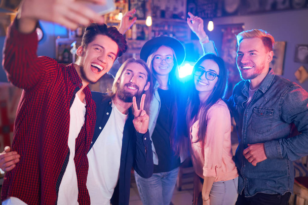 Selfie Time. Young Group of Friends Partying In A Nightclub And Toasting Drinks. Happy Young People With Cocktails At Pub. The People Have A Great Mood And They Smile A Lot - Фото, изображение