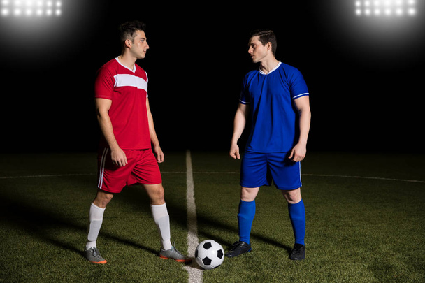 Повна довжина двох футболістів, що стоять на центральній лінії, з футболом, готовим розпочати матч
 - Фото, зображення