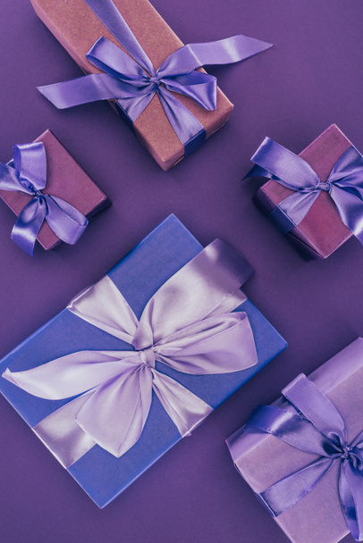 вид сверху на декоративные подарочные коробки с лентами и бантами на фиолетовый
 - Фото, изображение