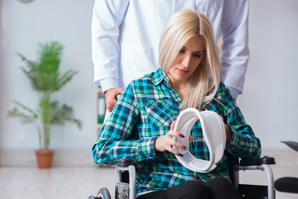 Mujer discapacitada en silla de ruedas visitando al médico hombre - Foto, imagen