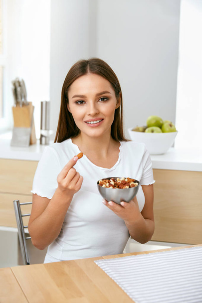 Healthy Food. Happy Woman Eating Nuts - Valokuva, kuva