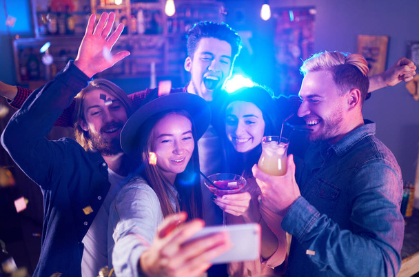 Selfie Time. Young Group of Friends Partying In A Nightclub And Toasting Drinks. Happy Young People With Cocktails At Pub. The People Have A Great Mood And They Smile A Lot - Photo, Image