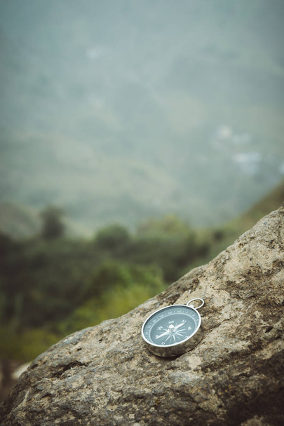 Trakking concept - Analogical Compass laying on the rocks with mountains in background - Fotoğraf, Görsel