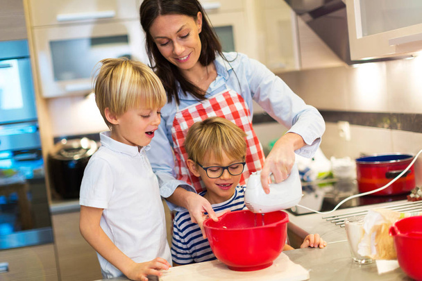 Mother and children baking together - Foto, afbeelding
