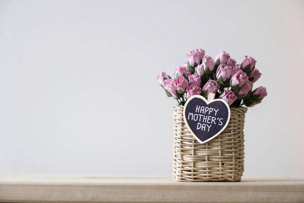 Ευτυχισμένος μητέρες μήνυμα ημέρα για ξύλινη καρδιά και τριαντάφυλλα ροζ χαρτί στο καλάθι στο τραπέζι με το αντίγραφο χώρος μίνιμαλ - Φωτογραφία, εικόνα