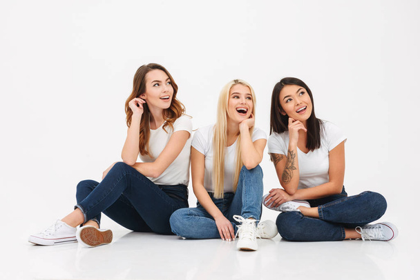 Young happy pretty girls friends sitting isolated - Foto, afbeelding