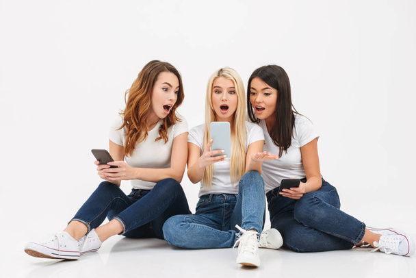 Three young shocked pretty girls friends chatting - Valokuva, kuva