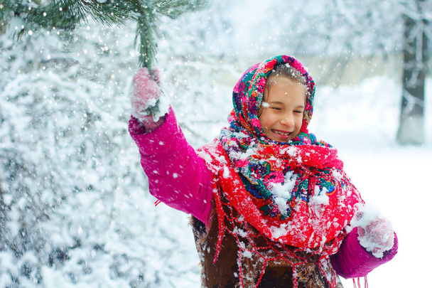 Dziewczyna w charakterze, dotykając trochę śniegu z choinki. - Zdjęcie, obraz
