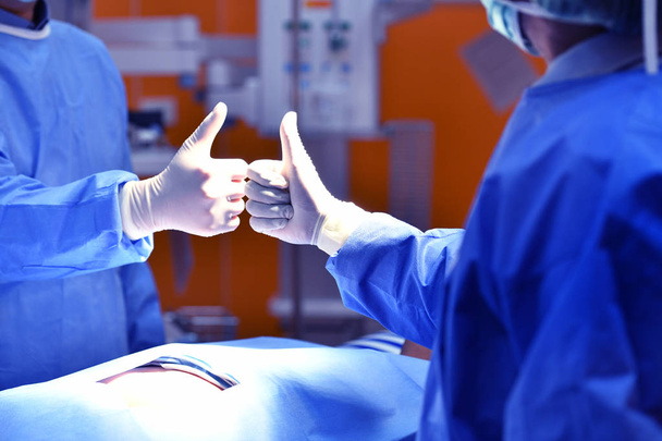 Team surgeon congratulating a successful operation in an operating room  - Photo, Image