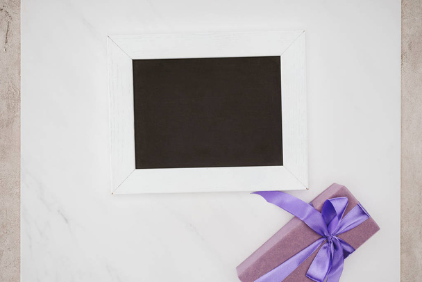 top view of blank chalkboard with gift box on white - Photo, Image