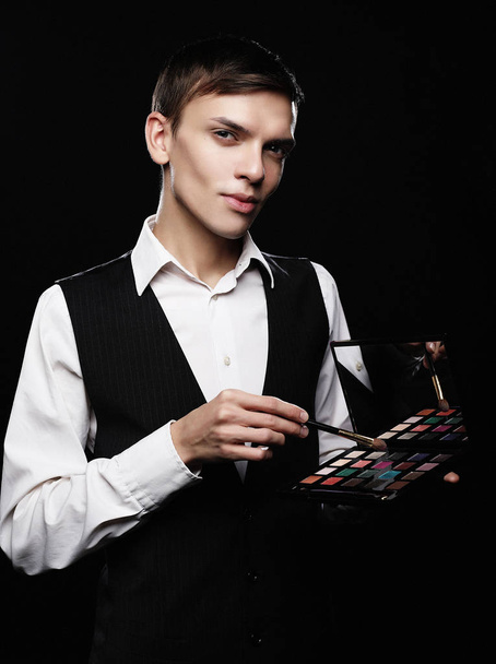 Young male make up artist holding shadow palette and brush.  - Foto, Bild