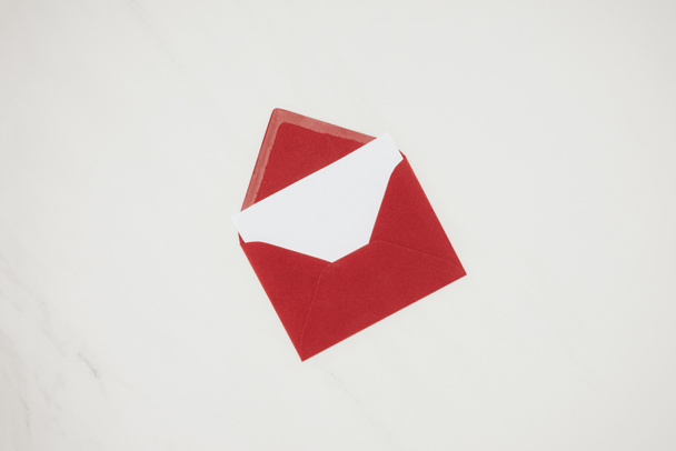 vista superior del sobre rojo abierto con papel en blanco aislado sobre blanco
 - Foto, Imagen