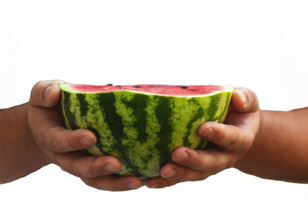 Um jovem tem metade da melancia nas mãos. O conceito
  - Foto, Imagem