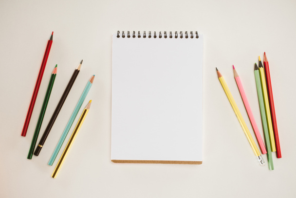 top view of blank notepad with colorful pencils isolated on white - Φωτογραφία, εικόνα