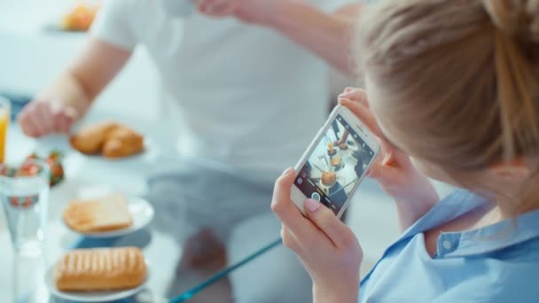 Young woman making photo of her breakfast for social media. Portrait of happy young couple during breakfast at home. - Filmmaterial, Video