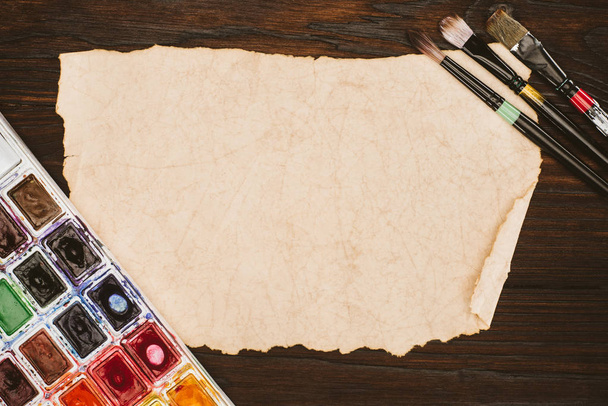 ahşap masa üzerinde boş yaşlı kağıt ve boya malzemeleri Üstten Görünüm - Fotoğraf, Görsel