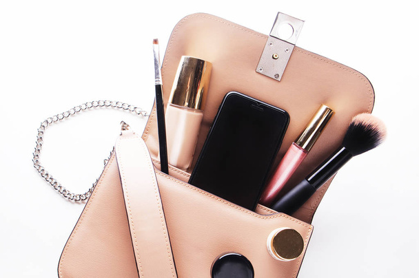 Flat lay of pink leather woman bag open out with cosmetics, acce - Fotografie, Obrázek