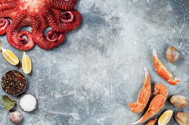 Морепродукти. Восьминіг, устриці, омари, креветки, молюски. Вид зверху на кам'яний стіл з пробілом для вашого тексту
 - Фото, зображення
