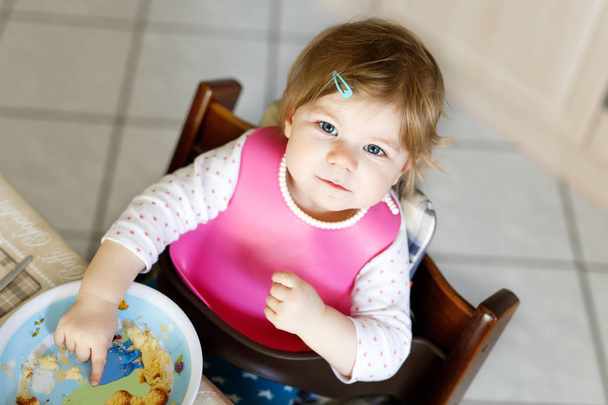 Adorable niña comiendo de la cuchara puré de verduras y puré. comida, niño, alimentación y concepto de personas - Foto, Imagen