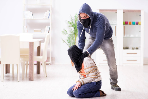 Armed man assaulting young woman at home - Fotó, kép