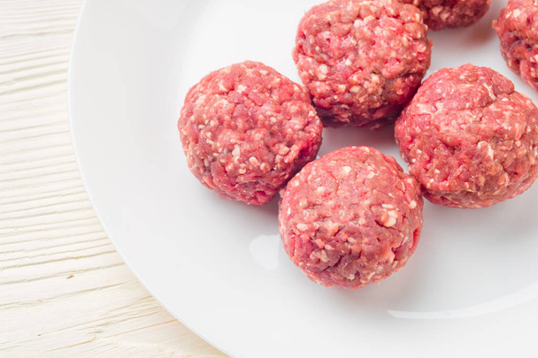 Meat balls from raw beef force-meat on a white plate - Fotografie, Obrázek