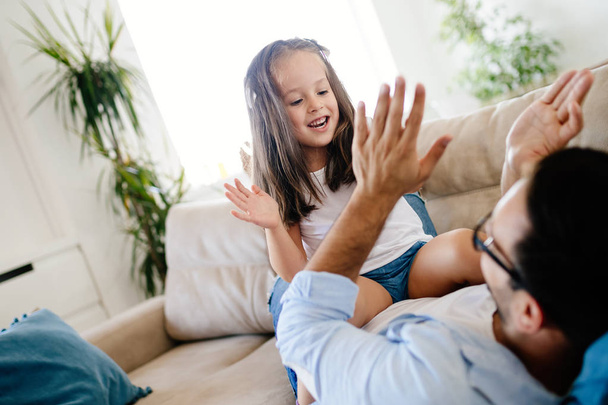 Portrait of father and daughter playing at home together - Photo, image