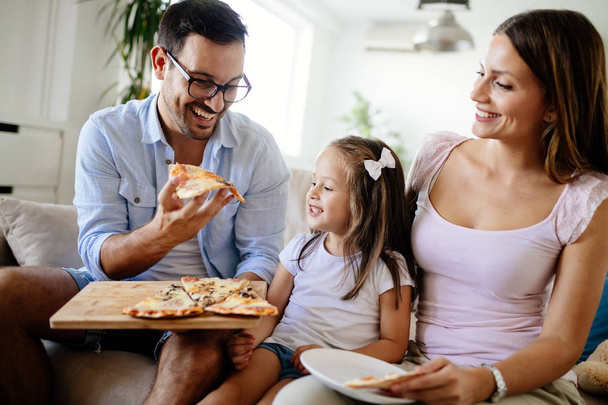 Happy smiling family sharing pizza together at home - Foto, immagini