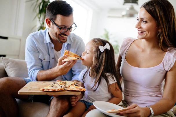 Happy smiling family sharing pizza together at home - Foto, immagini