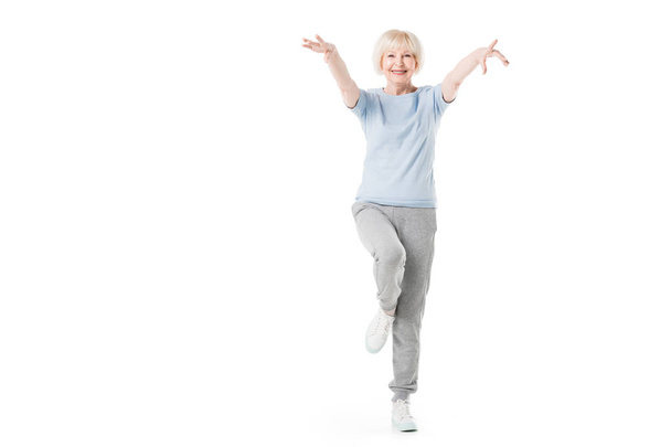 Sportiva anziana in piedi su una gamba isolata sul bianco
 - Foto, immagini