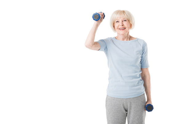 Smiling senior sportswoman with dumbbells in hands isolated on white - Photo, Image