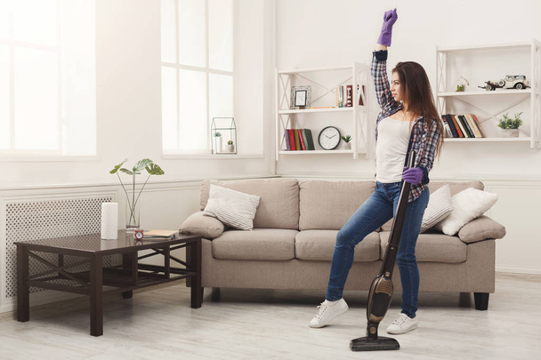 Mujer feliz limpieza en casa con aspiradora
 - Foto, Imagen