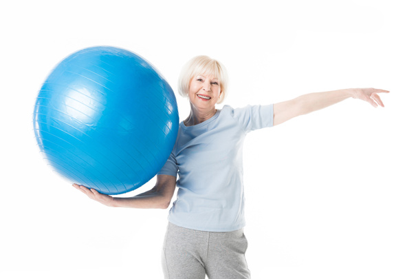 Sonriente deportista senior sosteniendo pelota de fitness en una mano aislada en blanco
 - Foto, imagen
