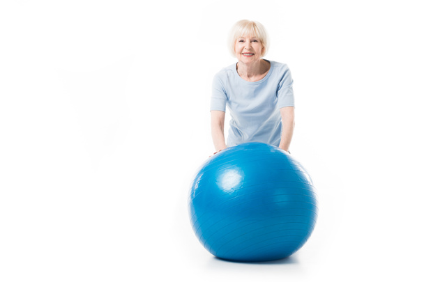 Porträt einer lächelnden Seniorin mit Fitnessball auf weißem Hintergrund - Foto, Bild