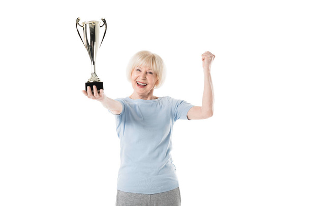 Senior sportswoman holding trophy in hand isolated on white - Photo, Image