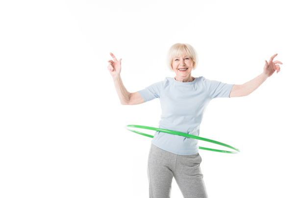 Усміхнена старша спортсменка робить вправи на обручі ізольовані на білому
 - Фото, зображення