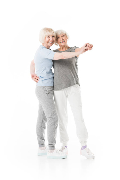 Two senior sportswomen doing exercise isolated on white - Foto, immagini