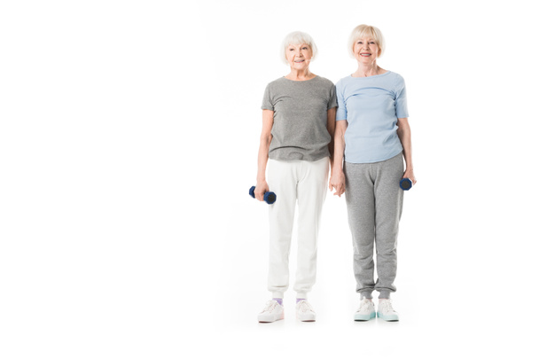 Two senior sportswomen with dumbbell in hand isolated on white - Photo, Image