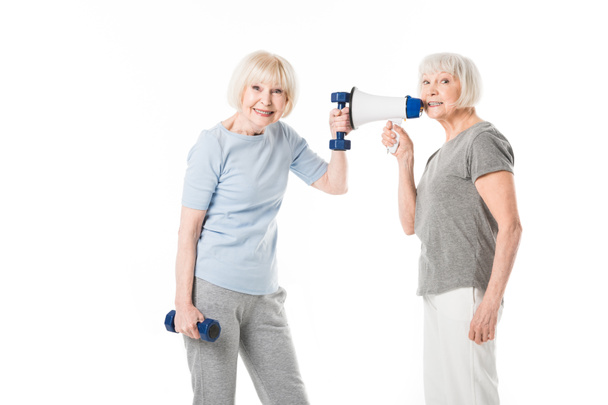 zwei Seniorinnen mit Kurzhanteln und Megafon isoliert auf weiß - Foto, Bild