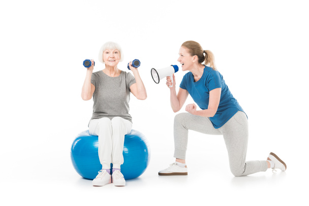 Coach with megaphone and sportswoman with dumbbells and fitness ball isolated on white - Foto, Imagem