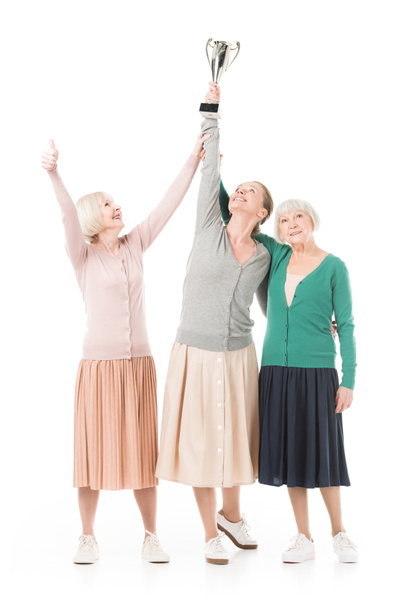 Κομψό γυναίκες που γιορτάζουν με Κύπελλο τρόπαιο που απομονώνονται σε λευκό - Φωτογραφία, εικόνα